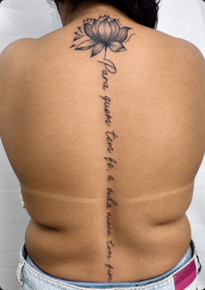 Tatuagem com escrita e desenho nas costas